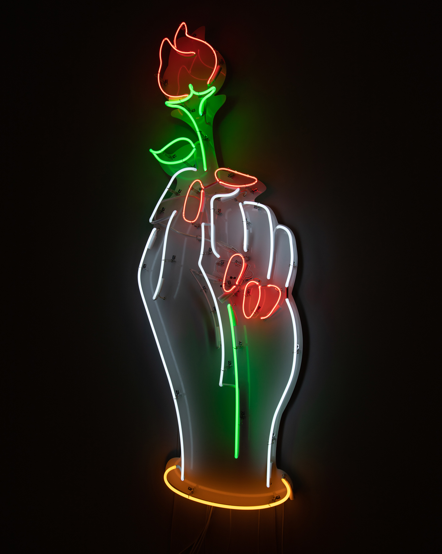 Neon sign of a hand with painted nails holding a red rose