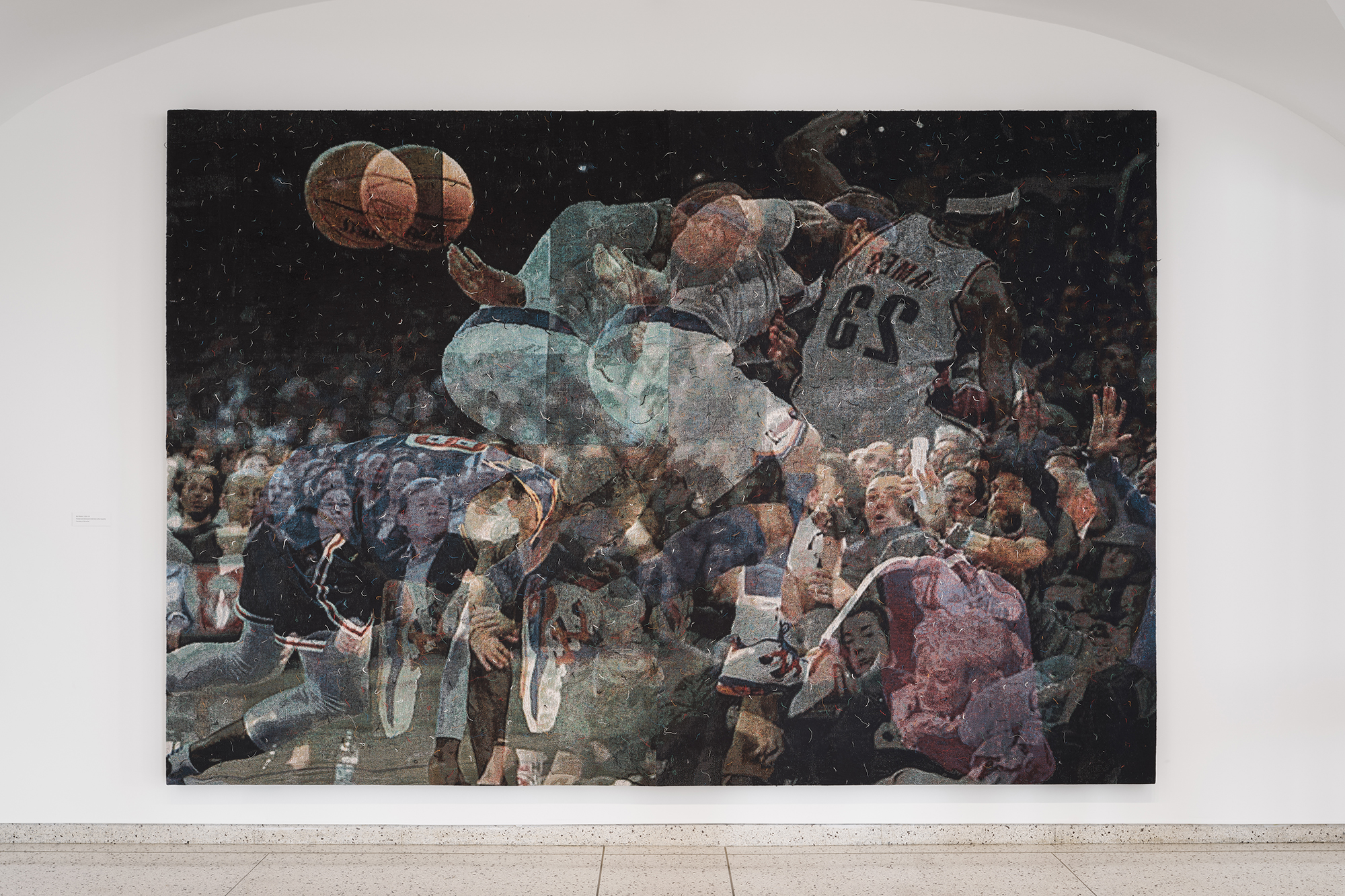 A woven and stretched tapestry by artist Noel W Anderson depicting an enthusiastic audience with transparent images of basketball players overlaid.