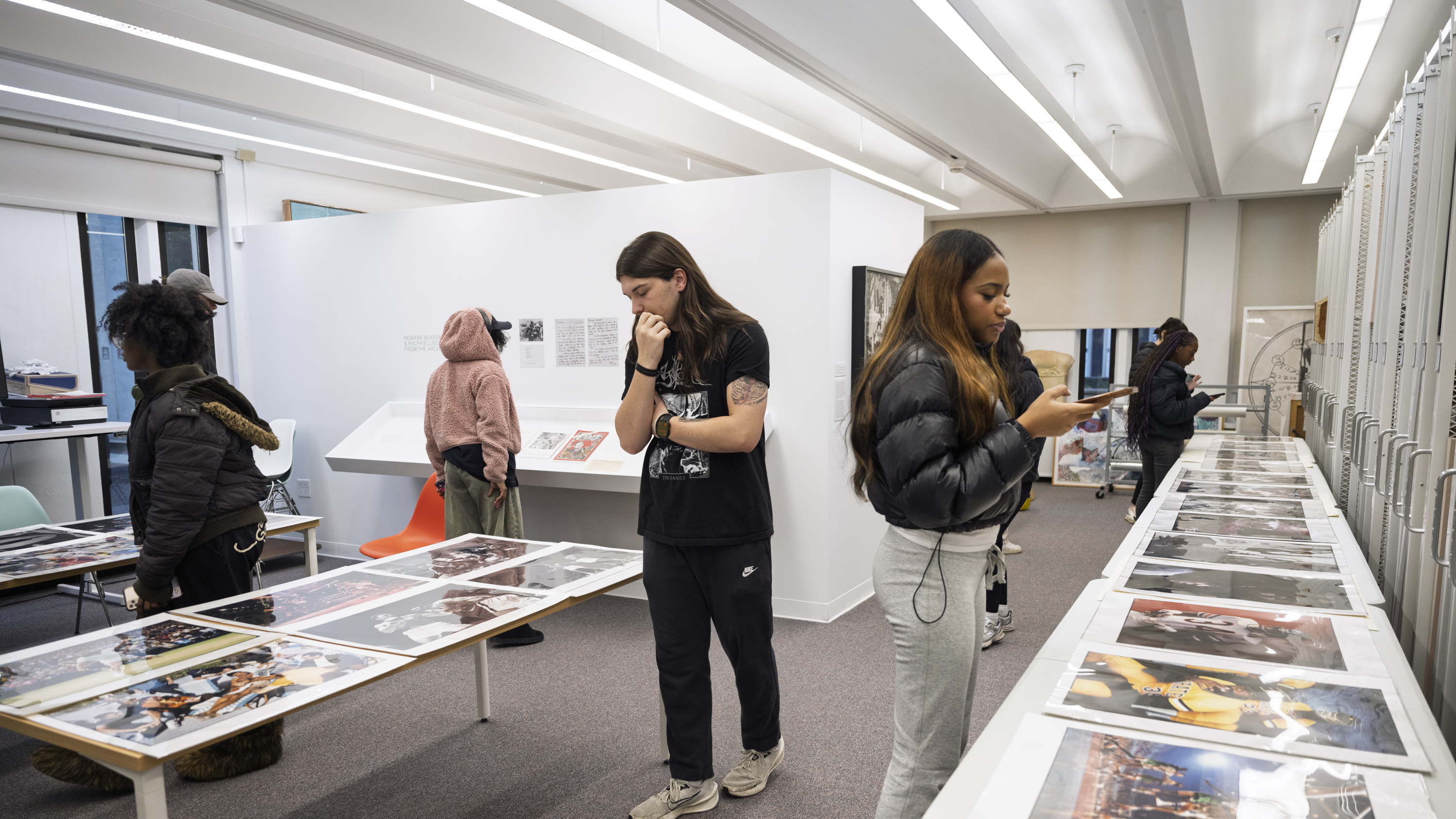 University students walk through the Collections Study Space intently looking at Walter Iooss’s photographs presented on tables.