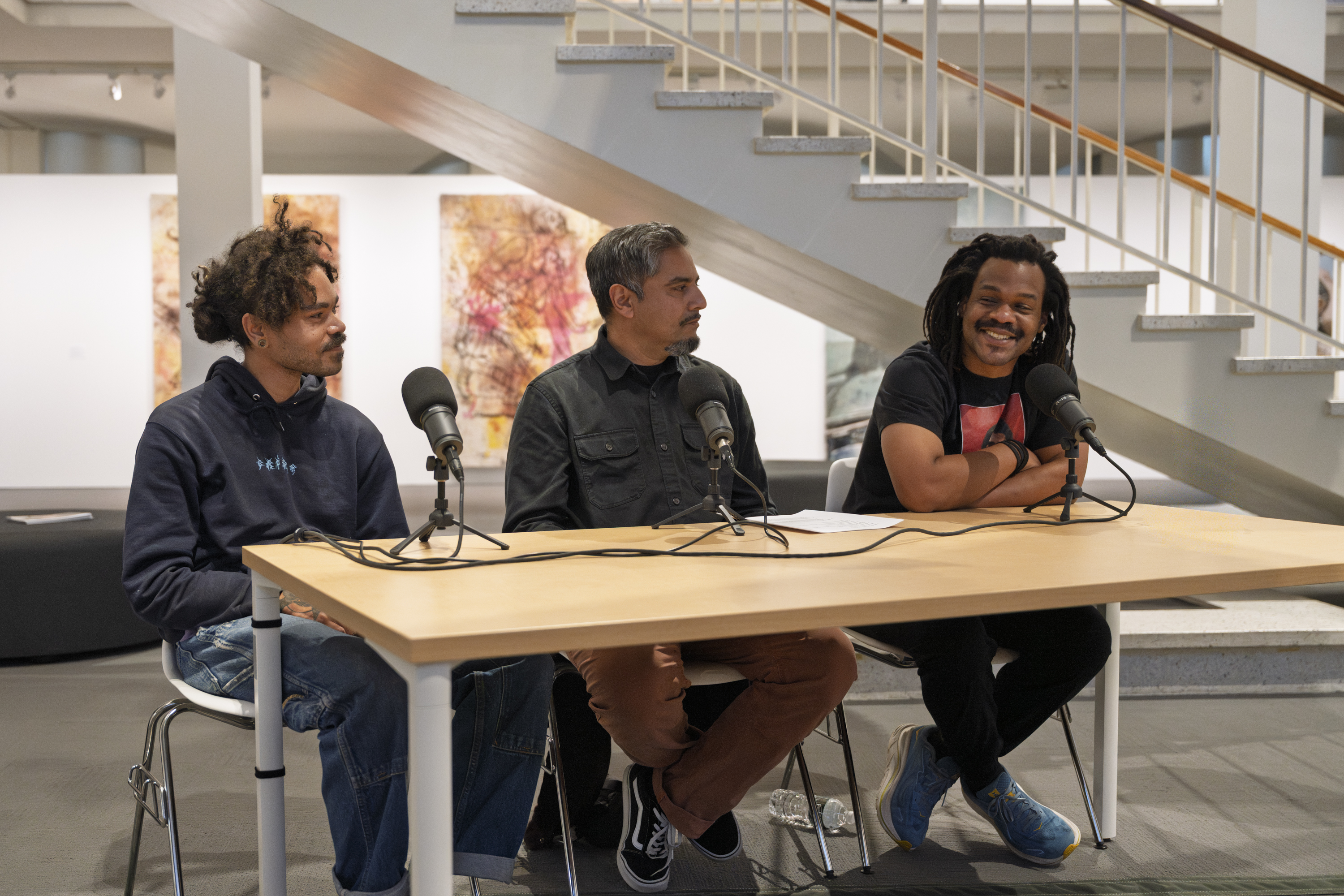 Solomon Bennett, Bhawin Suchak, and Noel W Anderson sit together at a table on the first floor of the University Art Museum, engaged in conversation for a public program at the University Art Museum. 